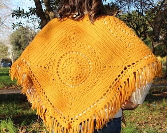 May include: A mustard yellow crochet poncho with a circular design and fringe trim.