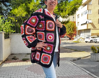 May include: A black crochet cardigan with colorful granny squares. The cardigan has a loose fit and long sleeves.