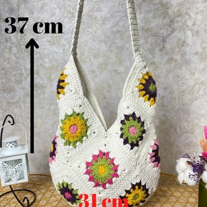 Op de afbeelding: Witte gehaakte tote bag met een bloemenpatroon. De tas is 37 cm hoog en 31 cm breed.