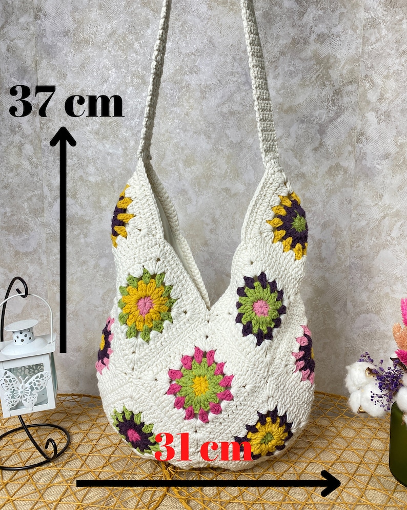 Op de afbeelding: Witte gehaakte tote bag met een bloemenpatroon. De tas is 37 cm hoog en 31 cm breed.