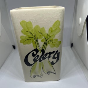 May include: White ceramic jar with a green and black illustration of celery and the word "Celery" written in black.