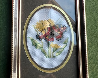 Haft krzyżykowy w stylu vintage. Motyl w ramce na żółtym kwiecie. Malutka dekoracja ścienna w formie galerii.