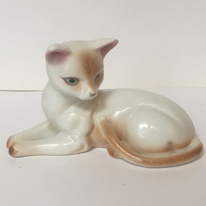Relaxing cat figurine. Beautiful vintage hand painted ceramic blue-eyed cat. White cat with brown tips and tail. Very pretty ornament.