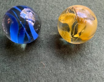 Set 2 vintage dobber shooter marbles. Two decorative glass marbles. Wire pull translucent with blue and yellow swirls.