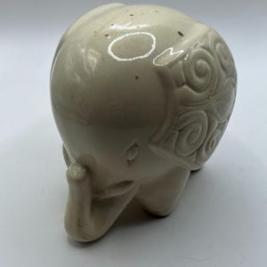 Quirky ceramic elephant figurine with decorated ears. Collectible cream elephant ornament.