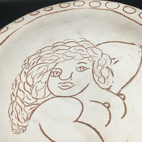 Decorative plate. Studio pottery terracotta plate with naked lady design. Unglazed Sgraffito style decoration.