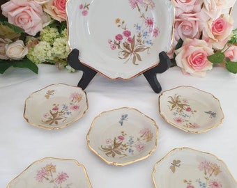 May include: Set of six white porcelain plates with a floral design and gold trim. The plates feature a delicate floral pattern with butterflies and a light brown background. The plates are perfect for serving desserts, appetizers, or snacks.