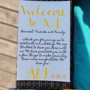 Nota di benvenuto con scritte a mano per gli ospiti di eventi di nozze fuori città da lasciare in hotel in calligrafia moderna