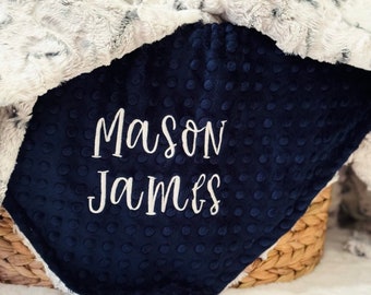 May include: A navy blue baby blanket with white polka dots and the names "Mason James" embroidered in white.