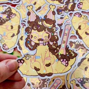 May include: A holographic sticker featuring a cartoon character with brown curly hair, round glasses, and a yellow body. The character is holding a pink and brown object. The sticker has a yellow and pink background with confetti.