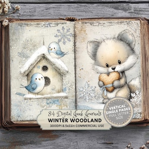 Puede incluir: Ilustración de un libro abierto con temática de bosque invernal. La página izquierda presenta una casita de pájaros con dos pájaros azules, y la página derecha muestra un lindo zorro sosteniendo una galleta en forma de corazón. La imagen incluye copos de nieve y el texto "84 Digital Junk Journals Winter Woodland".
