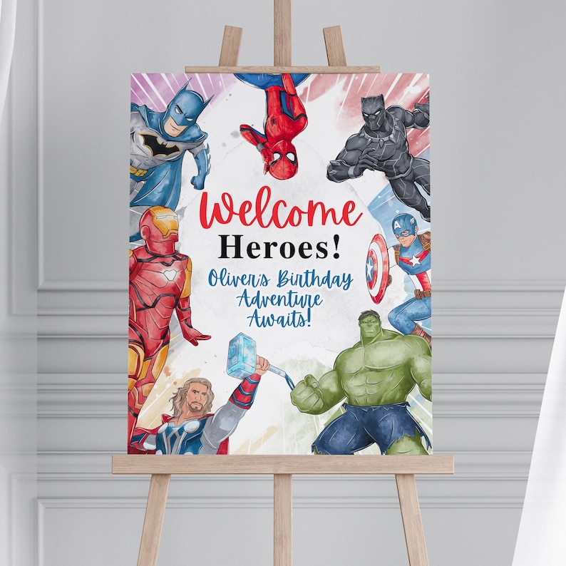 May include: A colorful sign on an easel featuring various superheroes. The sign reads "Welcome Heroes! Oliver's Birthday Adventure Awaits!" in red and blue text. The superheroes include Batman, Spider-Man, Black Panther, Captain America, Hulk, Iron Man, and Thor.
