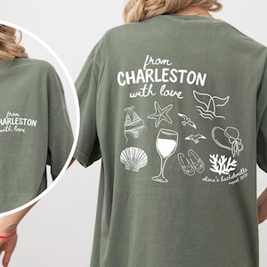 With love from Charleston customizable bachelorette party/ beach trip t shirt. On back has coastal doodles of wine glass, sea shell, bikini, etc. Comfort Colors t shirt on front says "from Charleston with love" city is customizable