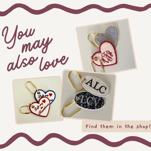May include: An image featuring several keychains with heart and oval shapes. The keychains are in various colors, including red, blue, and white, with embroidered text and designs. The text "You may also love" and "Find them in the shop!" are also visible.