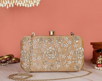 Pochette de soirée beige avec un design détaillé à paillettes, une texture douce et une bandoulière en métal pour mariage, fonctions royales et soirée.