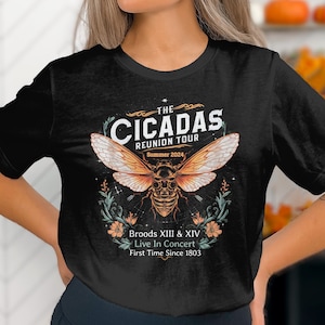 Pode incluir: Camiseta preta com um gráfico de um inseto cigarra com o texto "The Cicadas Reunion Tour Summer 2024 Broods XIII & XIV Live In Concert First Time Since 1803"