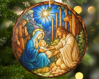 Może przedstawiać: Okrągła ozdoba świąteczna przedstawiająca scenę religijną z Maryją, Józefem i małym Jezusem. Grafika jest obramowana brązową obwódką i złotym sznurkiem do zawieszenia. Tło przedstawia niebieskie niebo z jasną gwiazdą.