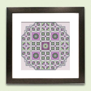 Könnte beinhalten: Gerahmtes Kreuzstich-Kunstwerk mit einem geometrischen Design in Lavendel, Grün und Grau. Das komplizierte Muster besteht aus Quadraten, Kreisen und Kreuzen, alles in einem dunkelbraunen Holzrahmen. Das Kunstwerk wird auf einem hellrosa Hintergrund präsentiert.