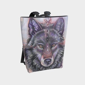 Op de afbeelding: Een rugzak met een gedetailleerde illustratie van een wolvengezicht. Het kunstwerk toont de wolf in tinten zwart, paars en bruin, met ingewikkelde details en een mystieke esthetiek. De tas heeft zwarte bandjes en een rechthoekige vorm.