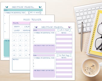 May include: Three printable pages for a gratitude journal and mood tracker. The pages are decorated with blue birds and have a light purple background. The pages include sections for dates, notes, and a mood tracker with a grid of numbers 1-30.