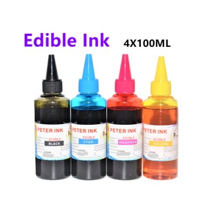 Op de afbeelding: Vier flessen eetbare inkt van 100 ml in zwart, cyaan, magenta en geel. De flessen zijn gelabeld met "Peter Ink" en "Edible [kleur]".