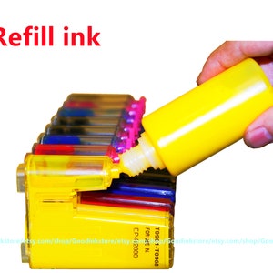 May include: A hand refilling a yellow ink cartridge with a yellow ink bottle. The ink cartridge is part of a set of color ink cartridges for a printer. The text on the ink cartridge reads "T09-1-T0968 FOR USE IN EP-F:2880".