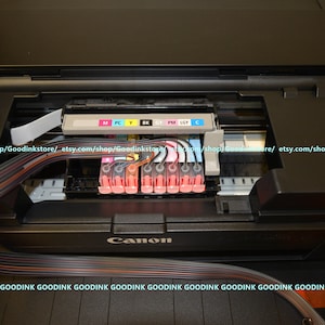 May include: Close-up of the inside of a Canon printer with the ink cartridges installed. The cartridges are labeled with the colors: M, PC, Y, BK, CY, PM, LGY, and C.