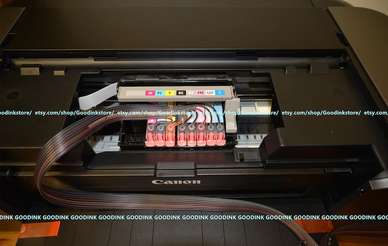 May include: Close-up of the inside of a Canon printer with the ink cartridges installed. The cartridges are labeled with the colors: M, PC, Y, BK, CY, PM, LGY, and C.