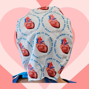 May include: A white surgical cap with a repeating pattern of red anatomical hearts and the text "Have you tried turning it off and on again?" in blue.