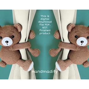 May include: Two brown crocheted teddy bears with white faces are holding onto a beige curtain. The bears are holding the curtain with their arms and are facing each other. The background is a teal blue color. The text "This is digital download file PDF, NOT finished product" and "Handmadify" are visible in the image.
