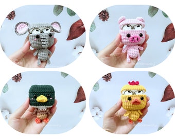 May include: Four crocheted animal AirPod cases. The cases are an elephant, a pig, a duck, and a chick. Each case has a cute face and is holding open AirPod cases.