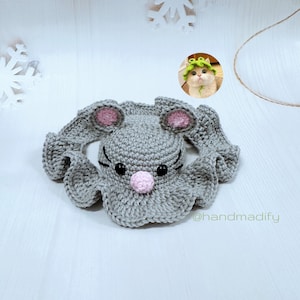 Könnte beinhalten: Graue gehäkelte Mützen in Form einer Maus mit rosa Ohren und Nase, schwarzen Augen und einem schwarzen gestickten Mund. Die Mütze liegt auf einer weißen Oberfläche. Der Text "@handmadify" befindet sich in der unteren rechten Ecke des Bildes.