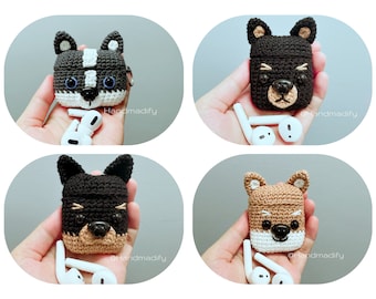 May include: Four crocheted Airpod cases, each featuring a different dog breed. The cases are black, brown, and white with embroidered facial features. The cases are held in hands, with the Airpods visible next to them.