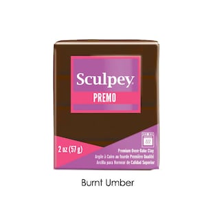 Peut inclure: Un bloc d'argile &agrave; cuire au four Sculpey Premo de couleur Ombre Br&ucirc;l&eacute;e de 57 grammes (2 onces). L'argile est emball&eacute;e dans une bo&icirc;te brune avec une &eacute;tiquette violette et rose.