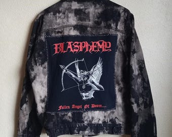 May include: A black and grey denim jacket with a large patch on the back. The patch features the word "BLASPHEME" in red gothic lettering above an illustration of an angel with a bow and arrow. The text "Fallen Angel Of Doom..." is below the illustration.