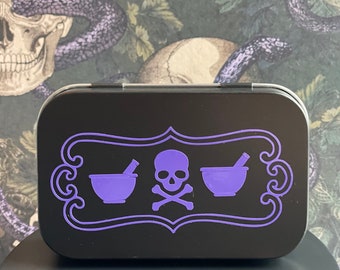 May include: A black metal tin with a purple design featuring a skull and crossbones, two mortar and pestle symbols, and the words "Poison" and "Antidote".