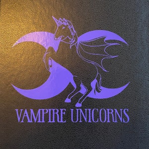Könnte beinhalten: Eine violette Silhouette eines Einhorns mit Fledermausflügeln, das auf zwei Mondsicheln steht. Der Text "Vampire Unicorns" befindet sich unter dem Bild.