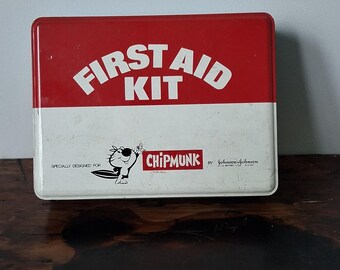 May include: Vintage red and white metal first aid kit with the words "FIRST AID KIT" in white. The kit features a cartoon chipmunk character and the text "CHIPMUNK". The kit is marked "by Johnson & Johnson".