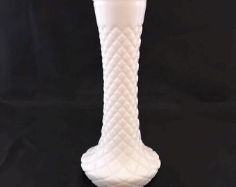 May include: White milk glass vase with a diamond pattern. The vase has a tall, slender body and a flared base.