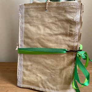 A5, hand crafted, coffee stained, hand bound book with white lace, green ribbons, sewn secret folders and pockets.