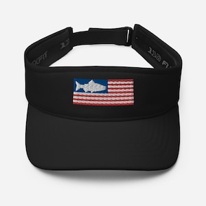 May include: Black visor with an embroidered American flag design, featuring a fish silhouette in the blue section. The visor has the text "110 Flexfit" on the side and is designed to protect the eyes from the sun.