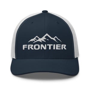 Puede incluir: Gorra de camionero azul marino y blanca con la palabra "FRONTIER" bordada en letras blancas debajo de un gráfico de cordillera. La gorra tiene una visera curva y una parte trasera de malla.