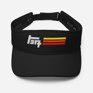 May include: A black visor featuring an embroidered white stylised logo on the front, accompanied by three horizontal stripes in yellow, orange, and red. The interior band includes the text Flexfit and 110 FITTED, with an adjustable back strap.