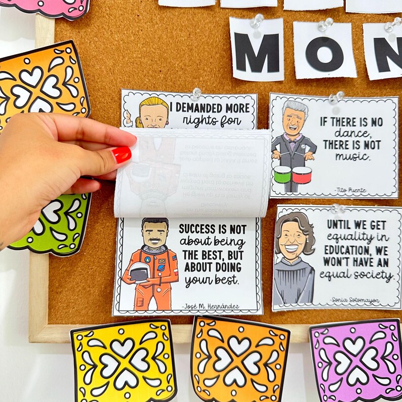 May include: A corkboard featuring inspirational quotes from notable Hispanic figures. The quotes are displayed on colourful cards with illustrations of the individuals. The corkboard is decorated with colourful paper cutouts.