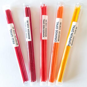 May include: Five clear tubes filled with colorful glass rods. The tubes are labeled with the colors: Red Opal, Deep Red Opal, Tomato Red Opal, Orange Opal, and Pumpkin Opal. Each tube has a white label with the color name and product code.