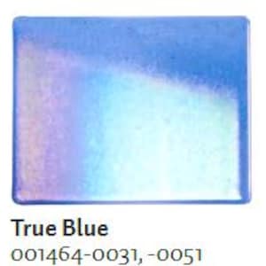May include: A rectangular, iridescent True Blue soap dish. The dish has a gradient of colors, transitioning from a deep blue to a light blue and white. The text "True Blue" is printed in black at the bottom of the image.
