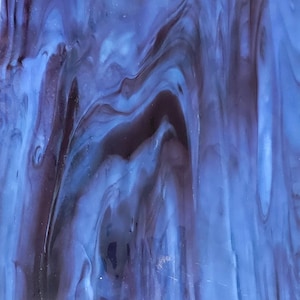 May include: Abstract stained glass with a swirling pattern of deep blue and dark purple hues. The glass has a textured appearance, with light reflecting off the surface. The design resembles flowing water or smoke.