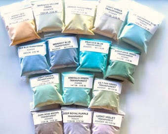 May include: A collection of small, clear plastic bags filled with various colored powders. Each bag has a label with the color name and other details. Colors include garnet red, marigold yellow, orange, light amber, and true blue.