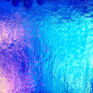 May include: Abstract image with a gradient of blues and purples. The surface has a rippled texture, creating a sense of depth and movement. The colors transition smoothly, with darker shades at the top and lighter hues towards the bottom.