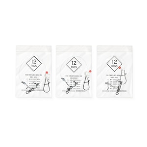 May include: Three clear plastic bags each containing 12 fishing rigs. Each bag has a white label with the number "12" inside a diamond shape. The rigs include hooks, swivels, and red beads. Text on the bags reads "FISH FINDER/RED DRUM RIG".